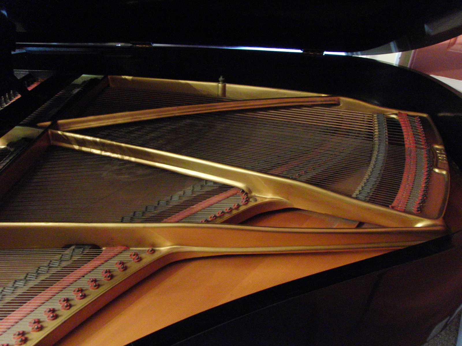 Grotrian Steinweg grand piano in black showing soundboard.